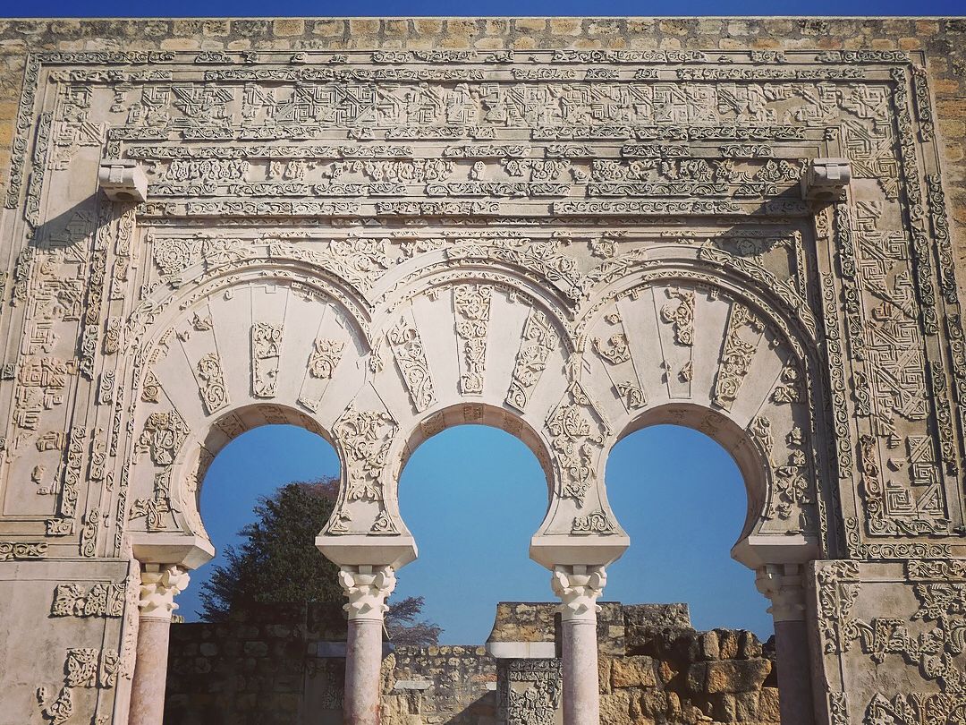 Arcos de herradura y decoración de piedra tallada en Medina Azahara, Córdoba.